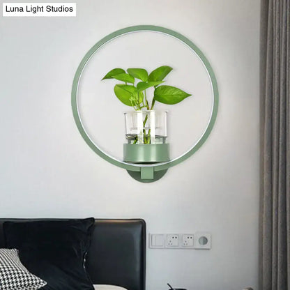 Modern silver wall light with mint-green circular plant pot and clear glass vase holding vibrant green leaves 110v-120v