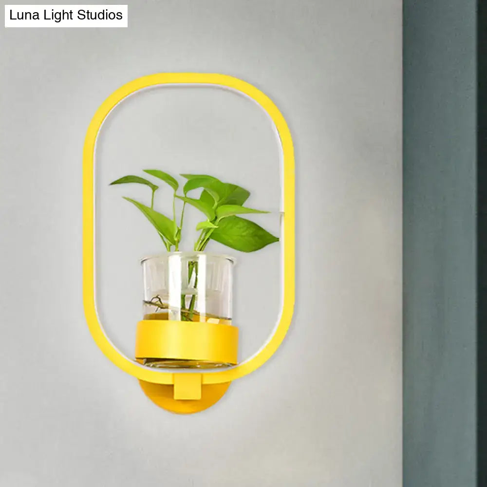 Modern silver wall light 110v-120v with yellow oval-shaped wall-mounted plant pot and clear glass container with green foliage