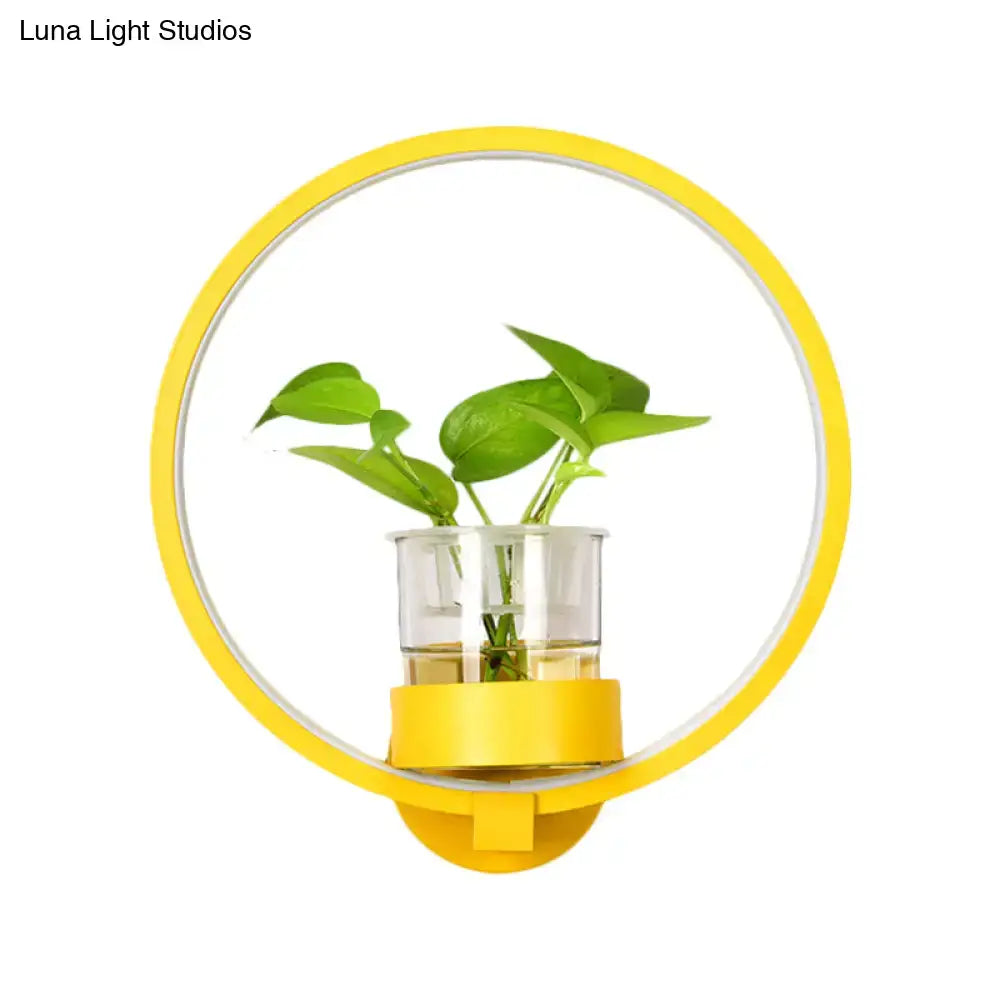 Modern silver wall light with yellow circular plant pot and clear glass vase holding green leafy plant for bedroom 110v-120v