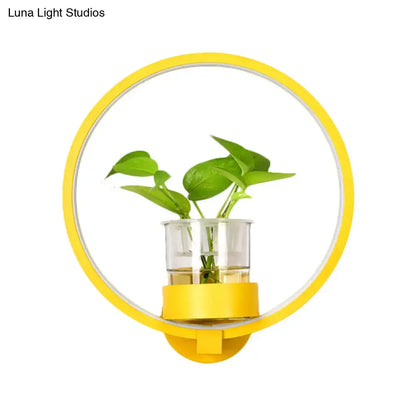 Modern silver wall light with yellow circular plant pot and clear glass vase holding green leafy plant for bedroom 110v-120v