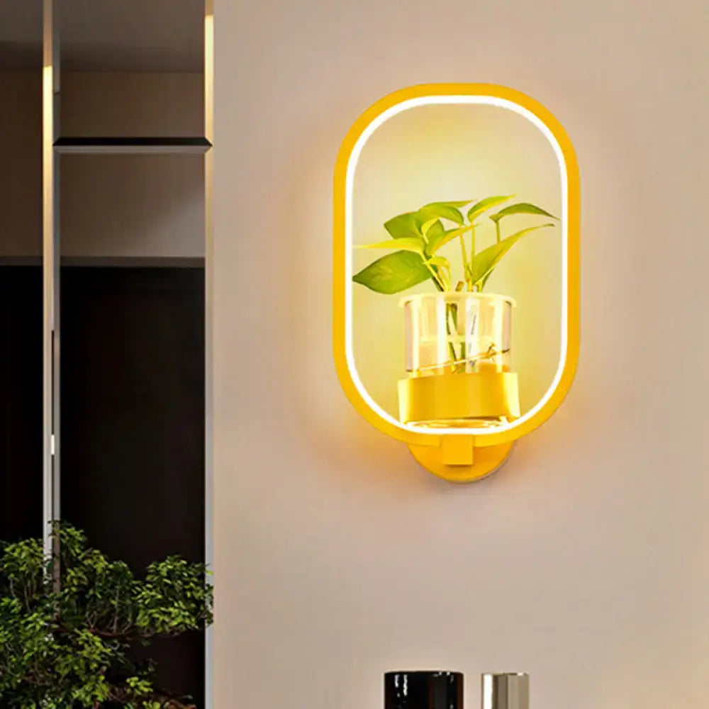 Modern silver wall light with yellow glowing LED frame housing a clear glass plant pot for 110v-120v bedroom use