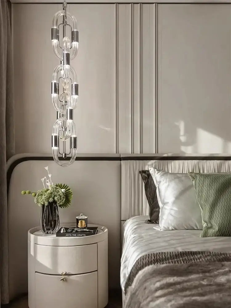 A modern silver and white crystal gold chain chandelier with metallic accents hangs above the bed decorbites crystal gold