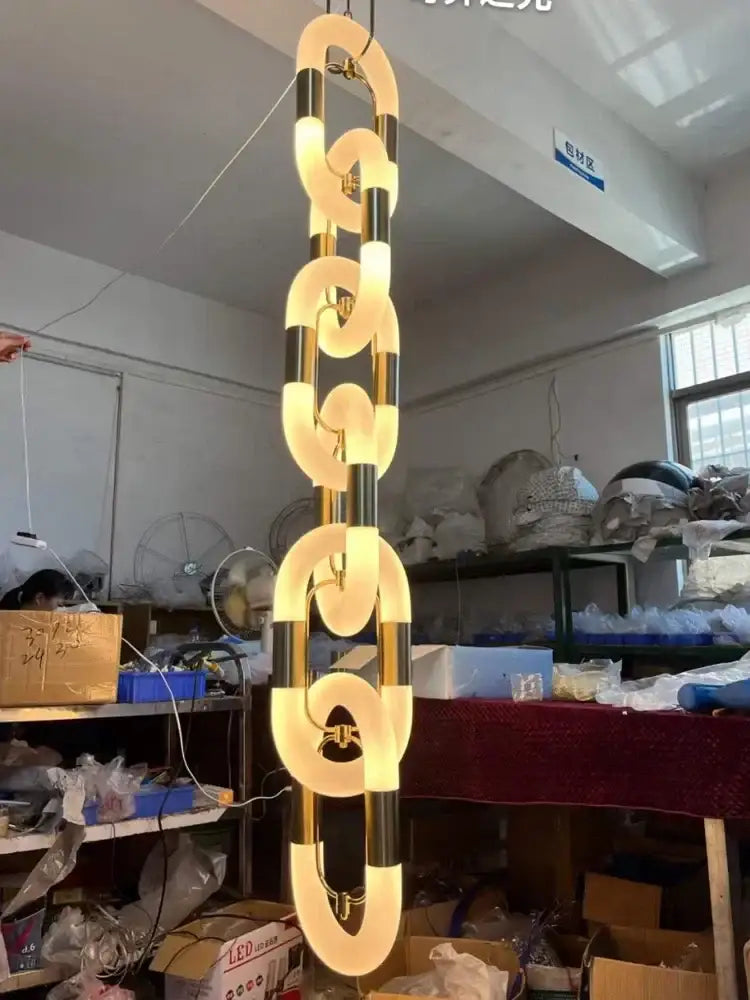 Modern silver and white crystal gold chain chandelier featuring sleek interconnected golden rings for dining room decorbites crystal gold