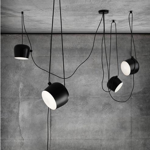 Black matte industrial pendant light with white interior, minimalist design.