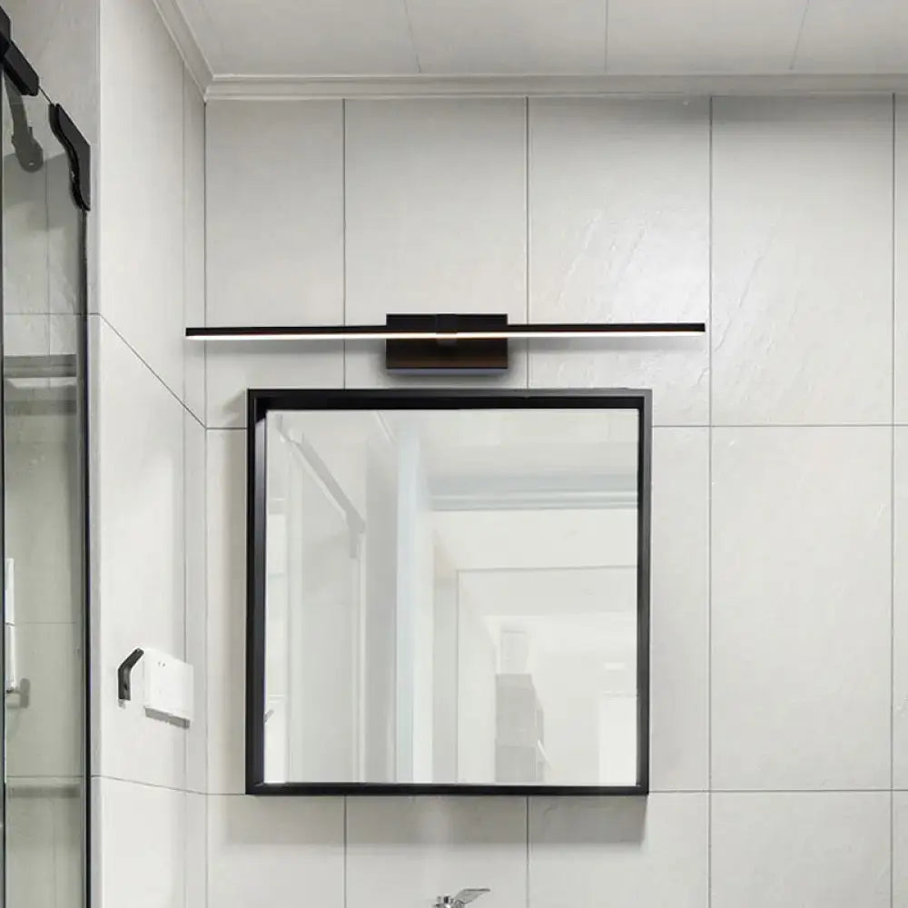 Modern sleek black led wall light with warm white light mounted above a black-framed rectangular bathroom mirror