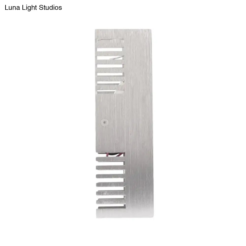 Silver brushed aluminum heat sink with vertical fins and central screw on the back of a modern slotted aluminum led wall sconce lamp