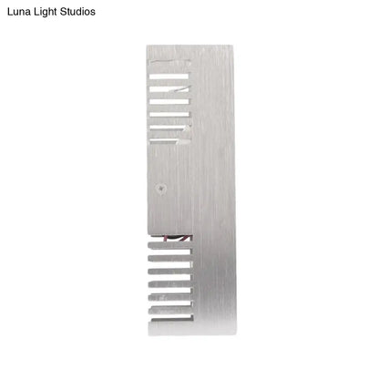 Silver brushed aluminum heat sink with vertical fins and central screw on the back of a modern slotted aluminum led wall sconce lamp
