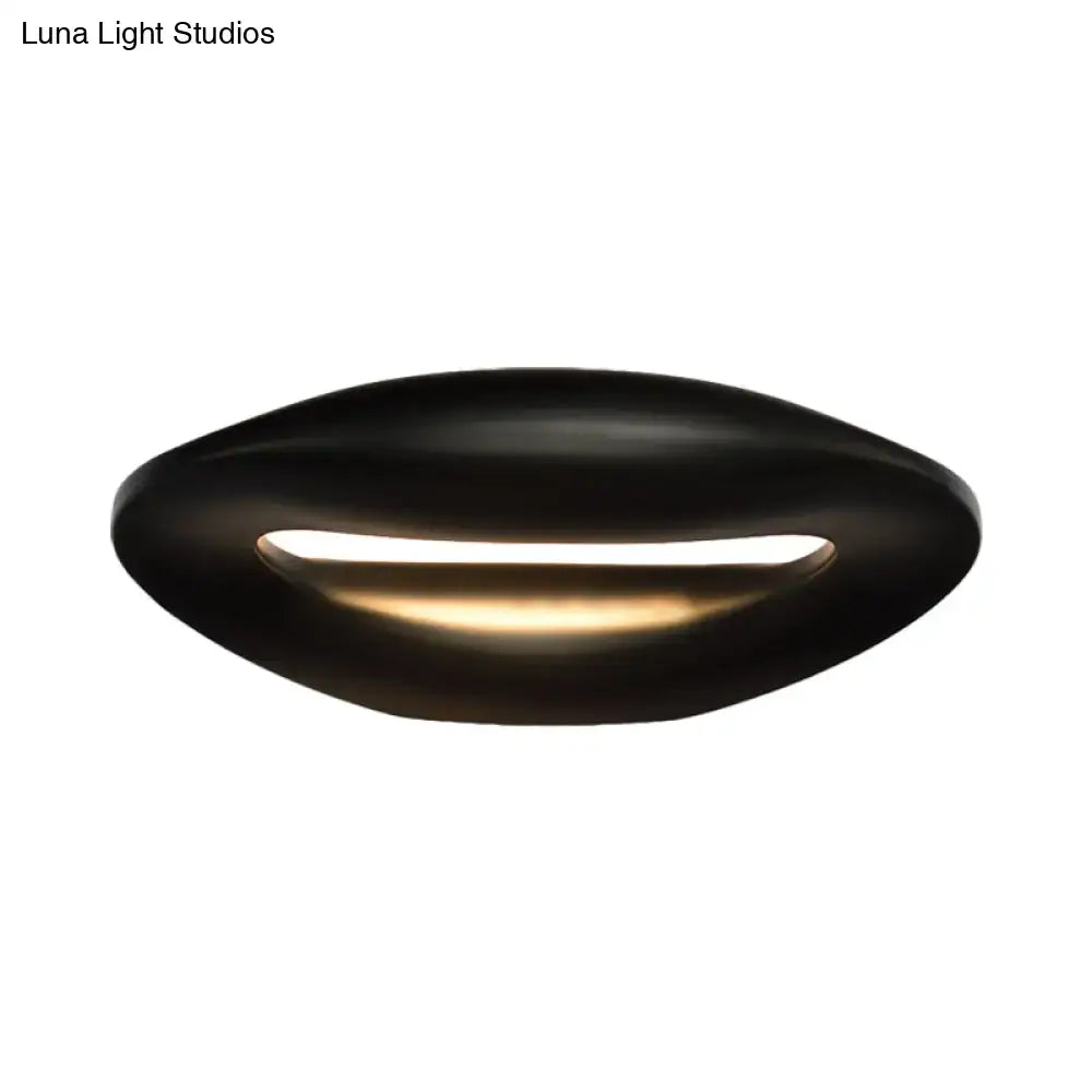 Black white modern wall lamp with smiling face design featuring a sleek oval shape and warm central led light
