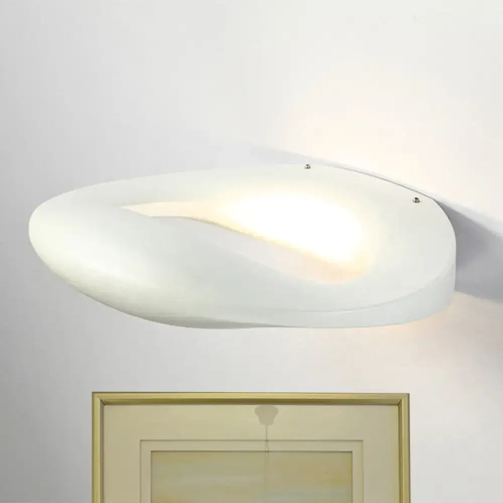 A sleek white frosted glass wall lamp with a smiling face design in black and white for modern corridors