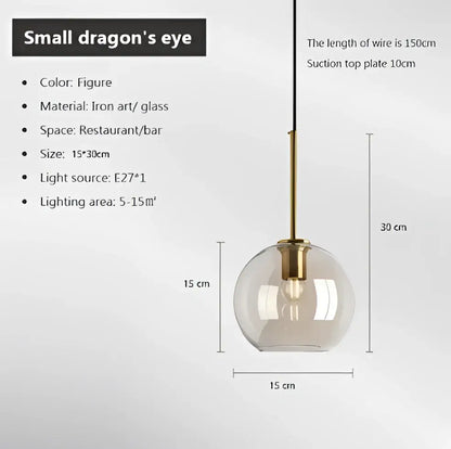 A sleek transparent glass globe pendant light with brass-finished metal fixture from a modern smoked glass pendant set of 6