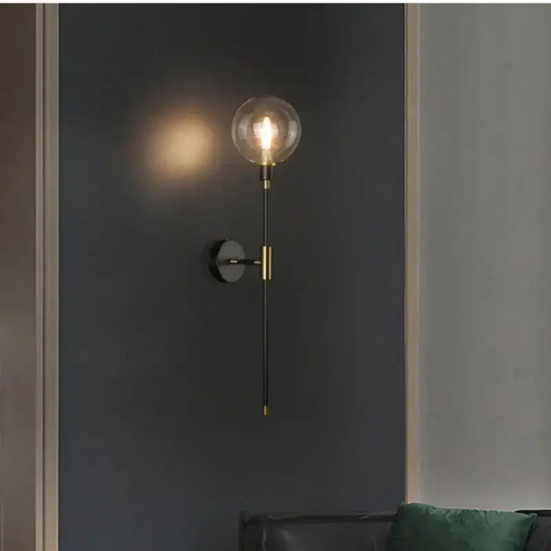 Modern wall light with brass accents black metal stem and clear glass globe bulb for decorbites glass ball led lighting