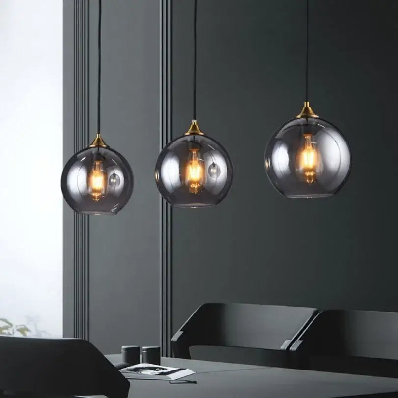 Modern smoked glass ball pendant lights with brass accents and exposed bulbs for kitchen and dining decorbites glass ball
