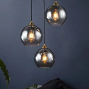 Modern smoked glass ball pendant lights triple set with brass accents and exposed filament bulbs for kitchen decorbites glass ball pendant