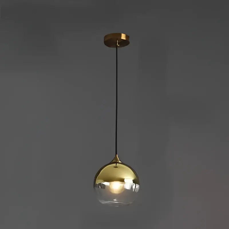 Gold-finished glass ball pendant light with clear smoked glass globe and black cord for kitchen and dining decorbites pendant lights