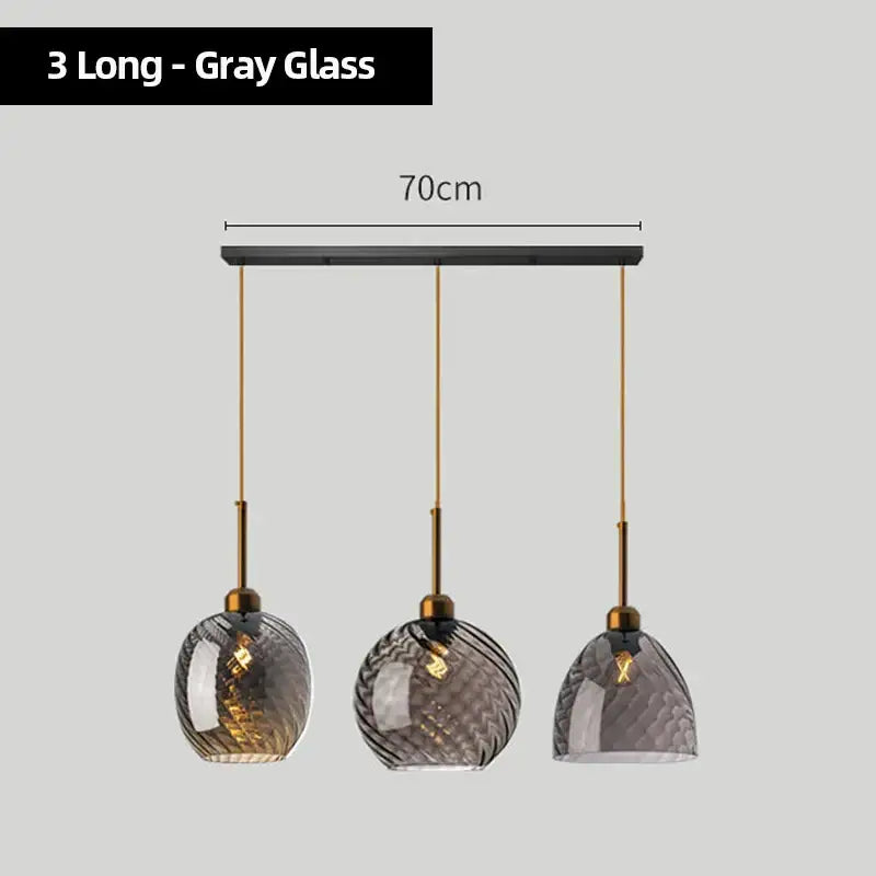 Set of three modern pendant lights with gray textured glass chandelier pendant shades and brass-finished metal fixtures