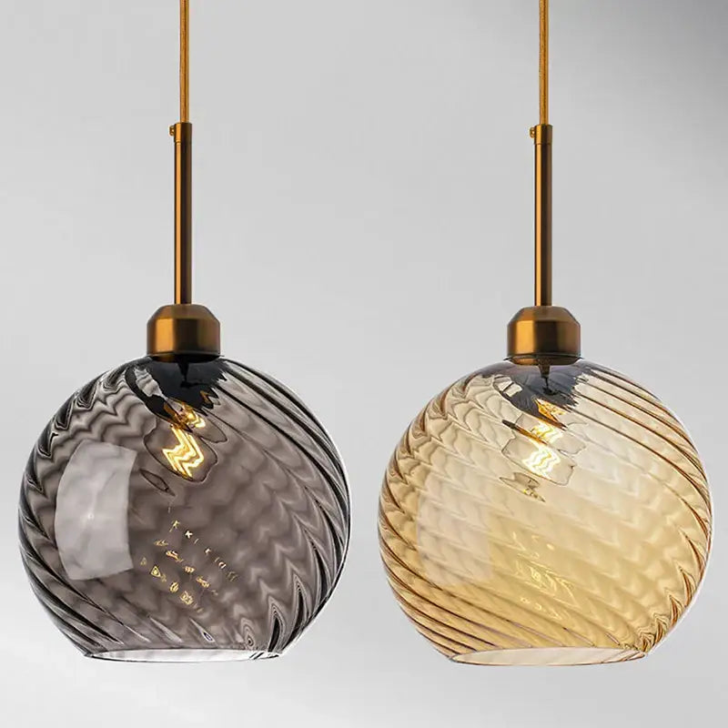 Two spherical glass chandelier pendant lights in smoky gray and amber with brass rods for modern kitchen use