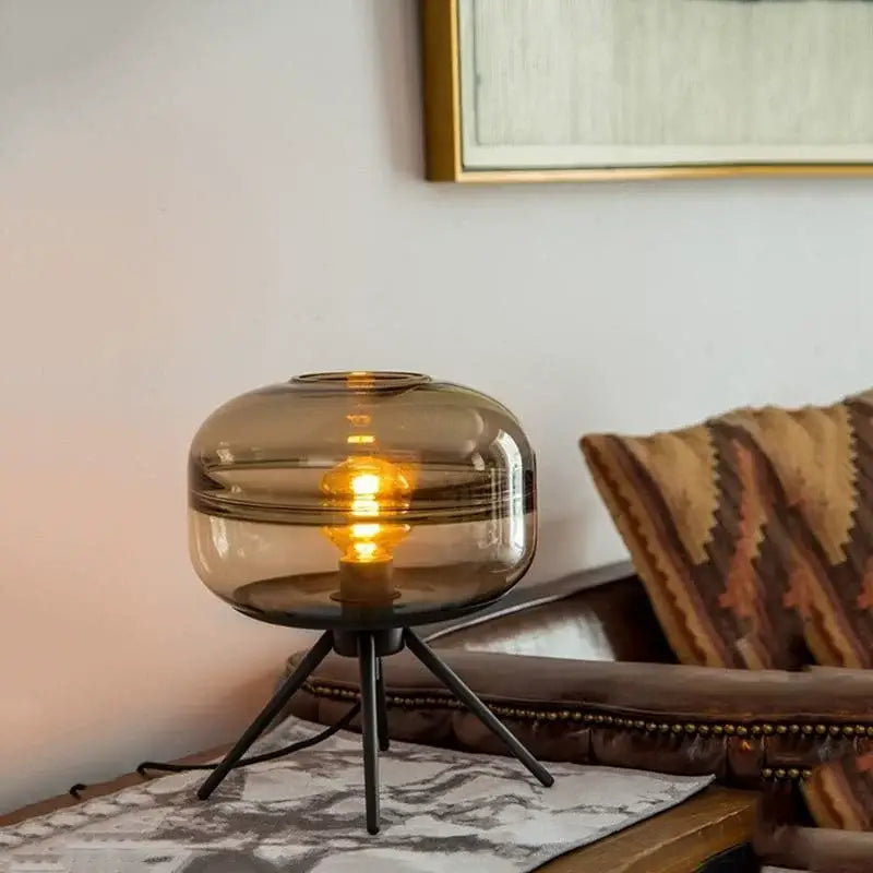 A warm-toned amber decorbites glass desk lamp with a tripod base ideal for modern smoked glass desk decor