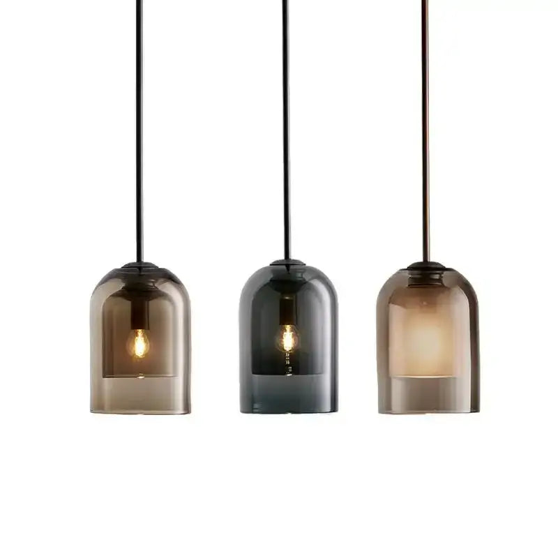 Three modern pendant lights with smoked glass led shades and black cords in a glass led chandelier for dining room