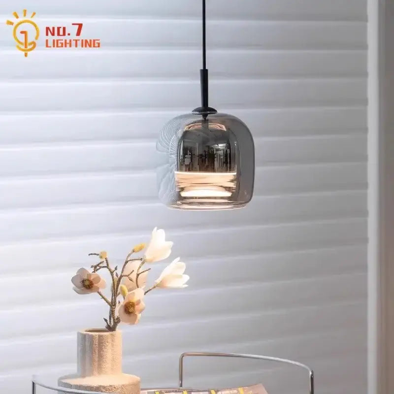 A modern smoked glass pendant light with translucent shade and black metal hardware perfect for bedroom led lighting