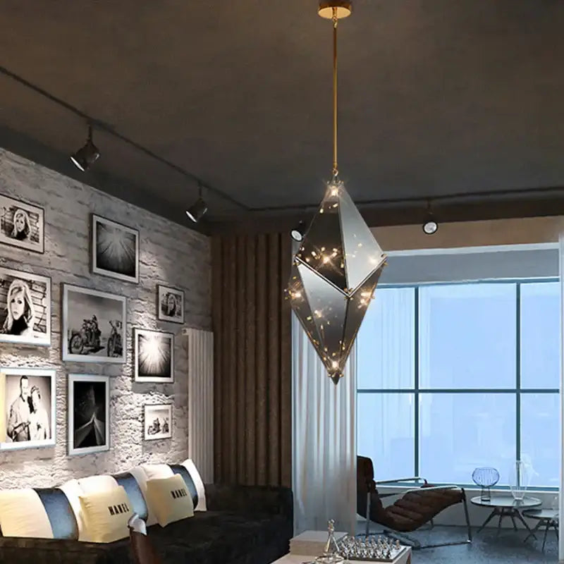 A modern smoky gray and amber diamond glass led pendant light with gold metal frame and mirrored facets for living room