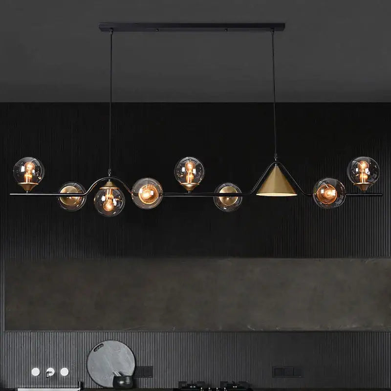 Black metal pendant light with smoky grey glass globes and central brass cone for modern dining room lighting