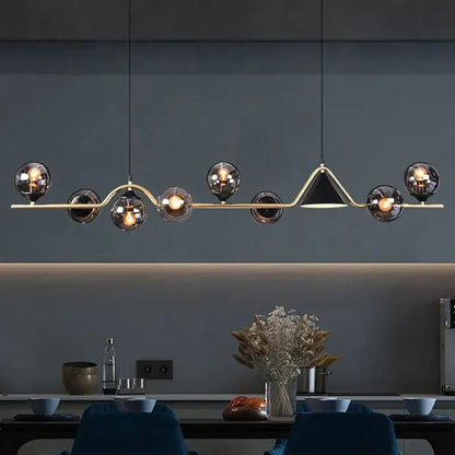 Modern pendant light with smoky grey glass bulbs and gold-toned triangular accent for dining room use