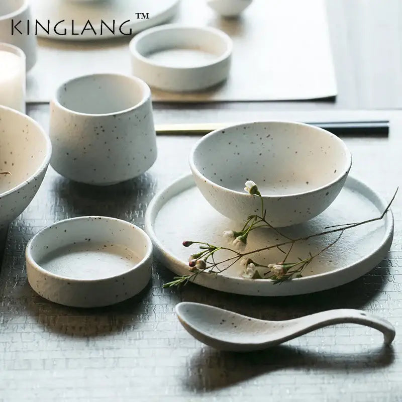 White ceramic dinner plate set with subtle speckled texture and smooth curved rim for modern dining use