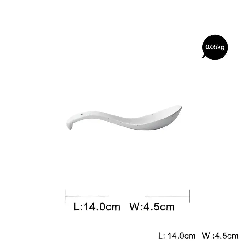 White ceramic spoon with a smooth curved handle from modern speckled white ceramic dinner plate set for dining use