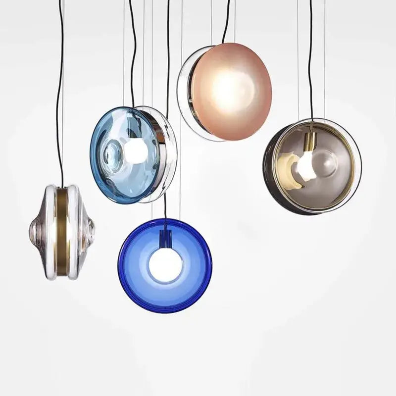 Modern spherical glass pendant lights in blue rose gold and clear glass with metallic accents for dining room use