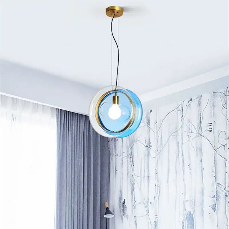 Modern blue and white glass pendant lights with brass-finished metal frame for elegant living space or dining room lighting