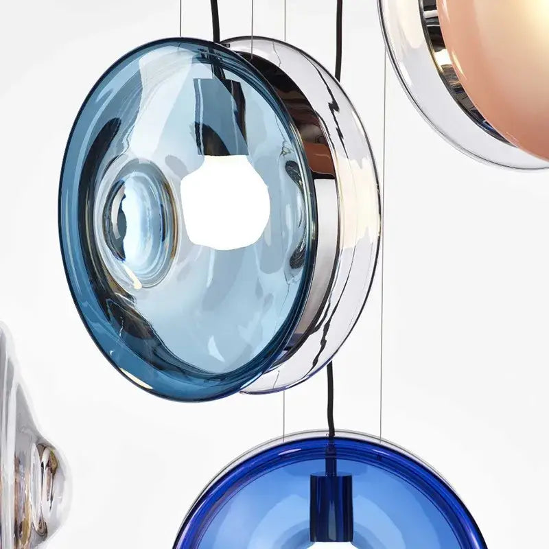 Modern spherical blue glass pendant lights with chrome metallic accents for dining room or living space lighting