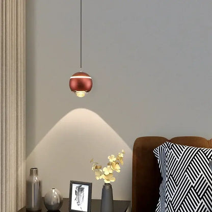 A sleek copper-finished modern spherical led bedside pendant light with warm glow for bedroom decorbites decor