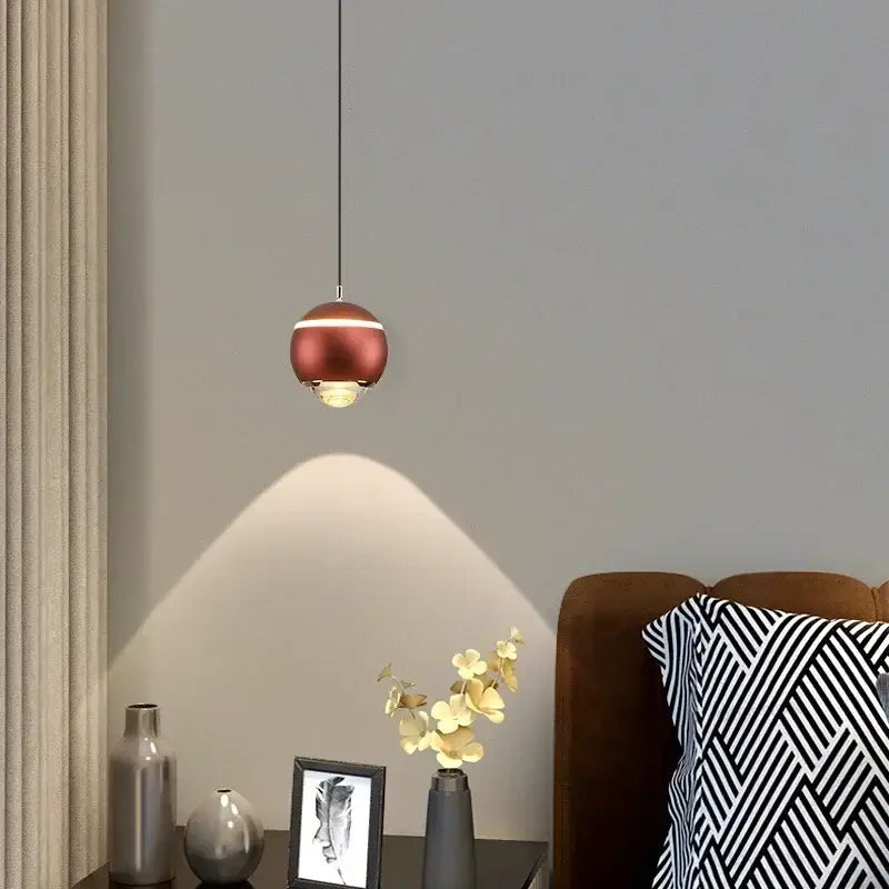A sleek copper-finished modern spherical led bedside pendant light with warm glow for bedroom decorbites decor