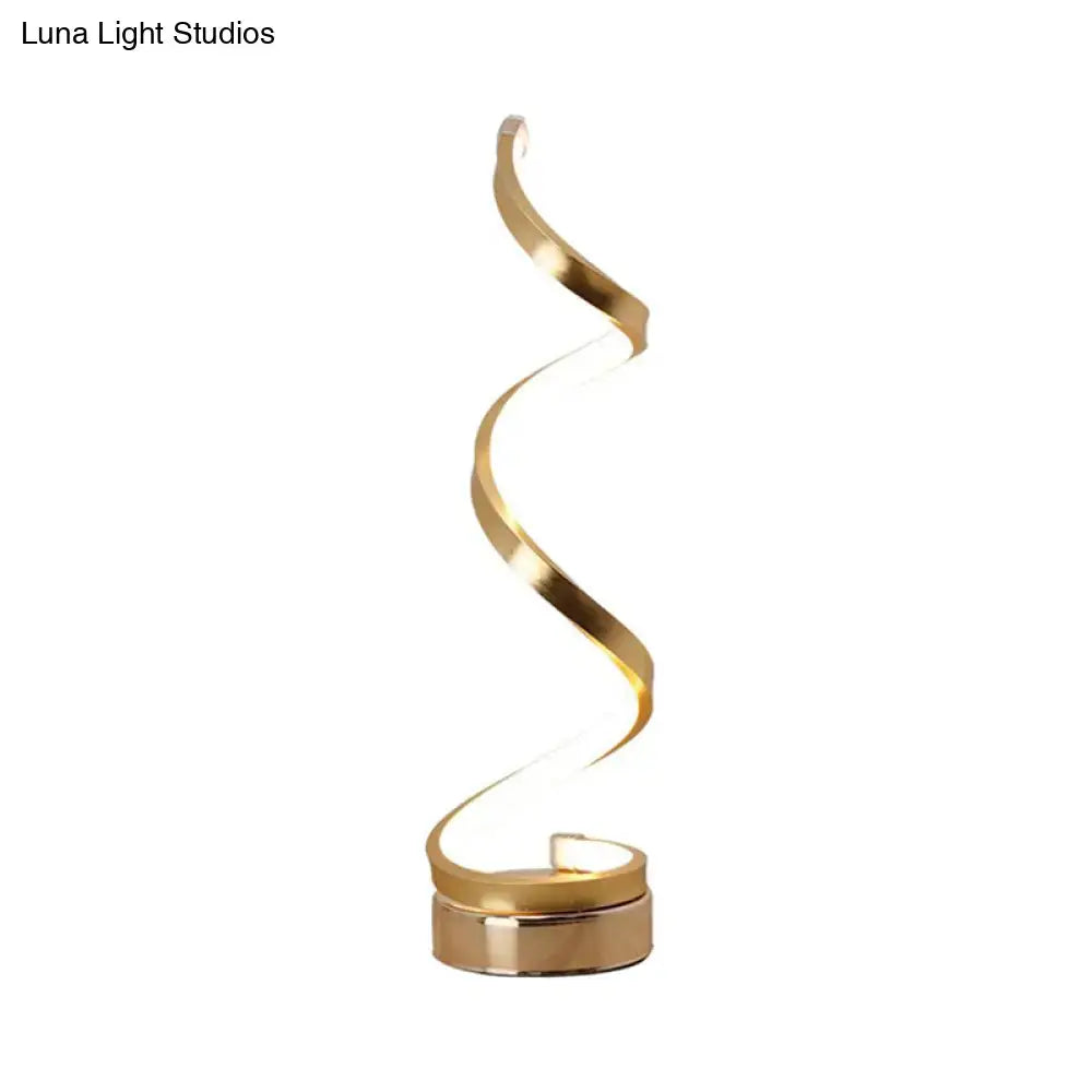A sleek gold finished spiral led table lamp with black white gold accents for modern bedroom task lighting