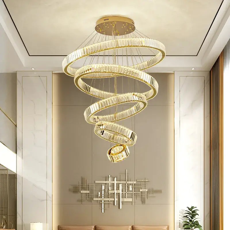 A modern spiral crystal circle led chandelier with gold metal rings suspended from a circular ceiling mount