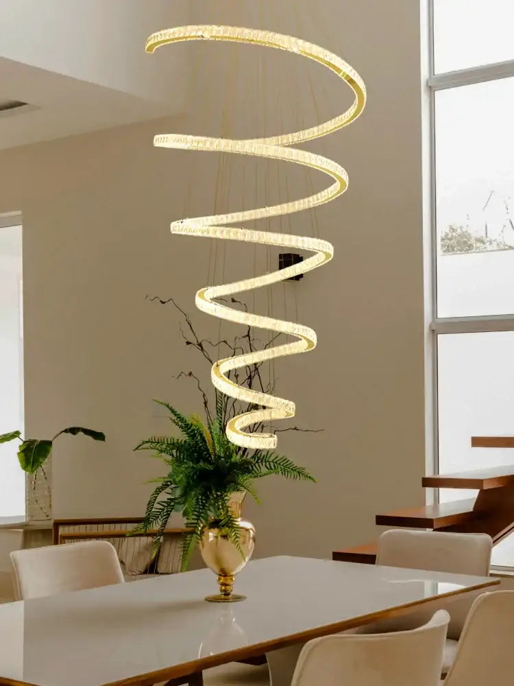 A modern spiral crystal pendant chandelier with golden finish and embedded led lights by decorbites crystal pendant
