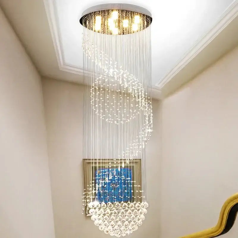 Modern spiral crystal staircase chandelier with cascading crystal strands and warm lights by decorbites crystal staircase