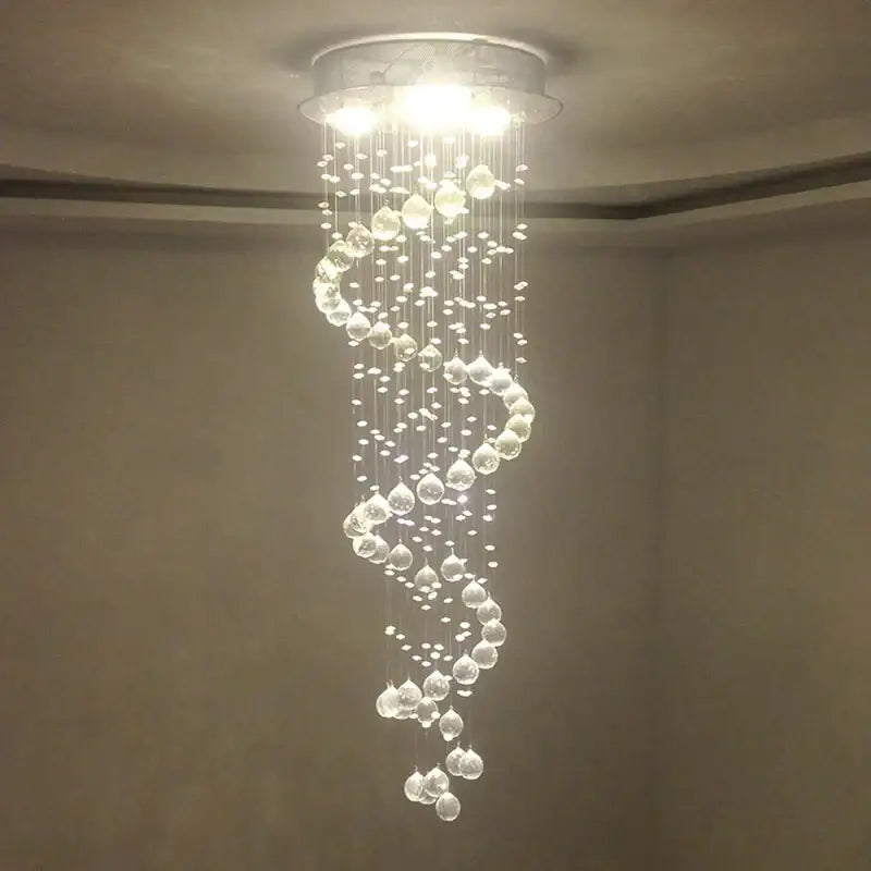 A modern spiral decorbites crystal chandelier with clear glass beads and droplets for living room staircase lighting