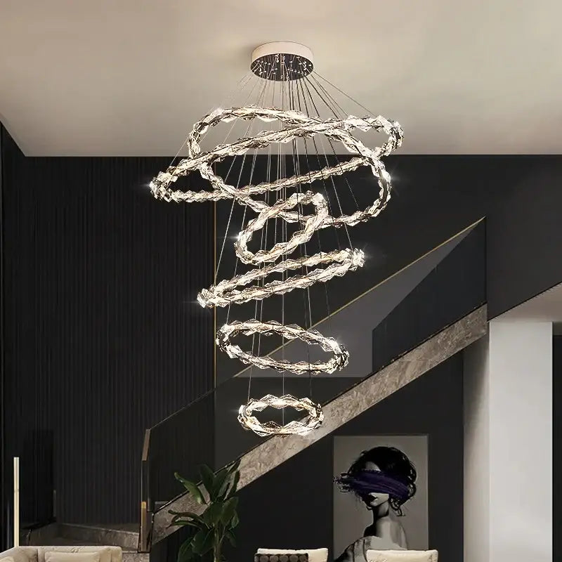 A modern spiral decorbites crystal chandelier with multiple glowing crystal LED rings for living room lighting