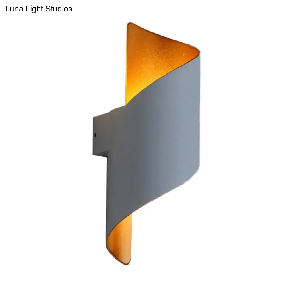 Modern spiral white and gold wall sconce with a sleek curved exterior and warm interior direct wired electric light