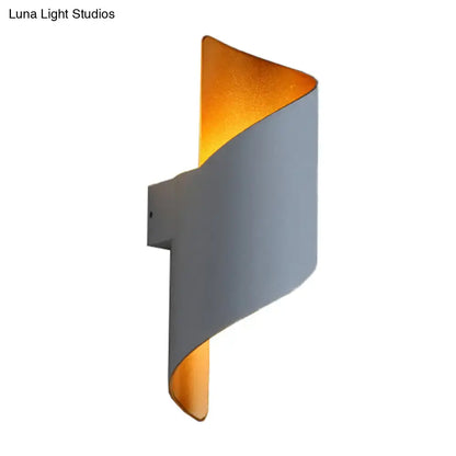 Modern spiral white and gold wall sconce with a sleek curved exterior and warm interior direct wired electric light