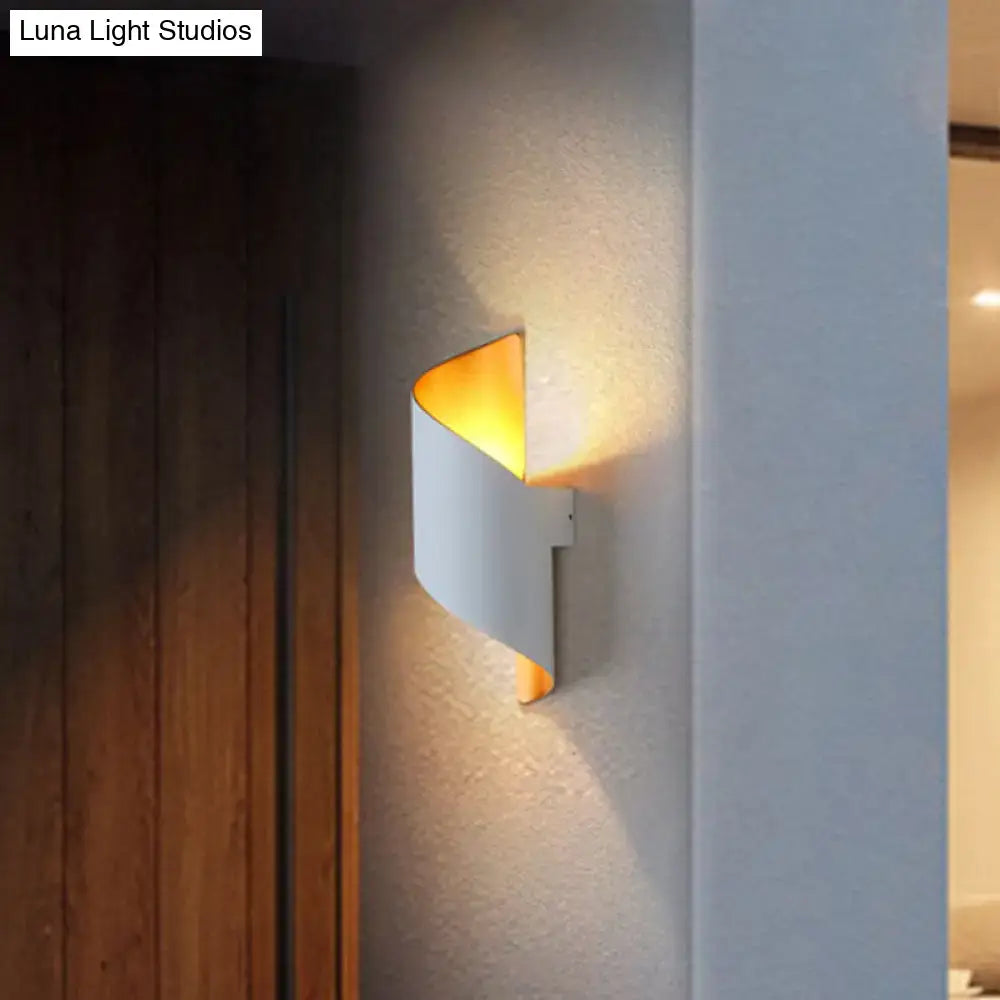 Modern spiral white and gold wall sconce with curved metal body and warm amber direct wired electric light for bedroom