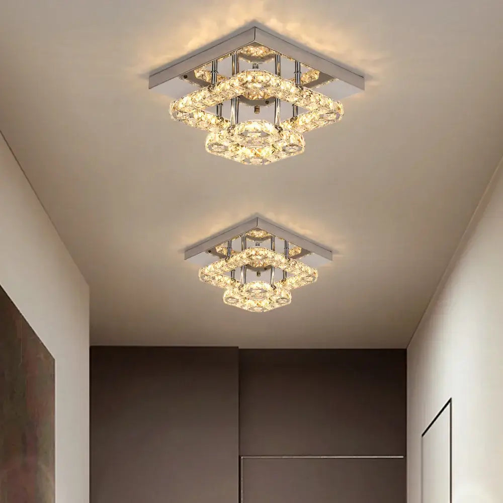 Two modern square chrome ceiling chandeliers with layered clear crystals emitting warm light decorbites crystal led