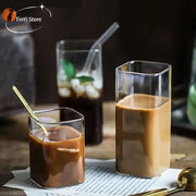 Modern clear square glass coffee tea tumblers with rounded edges filled with iced coffee and mint garnish