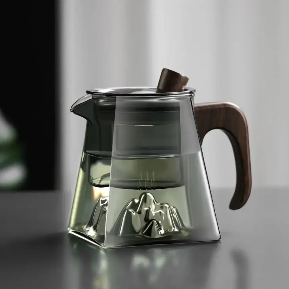 Modern square glass tea pot with wooden handle and lid featuring a metal mountain-shaped filter for brewing tea