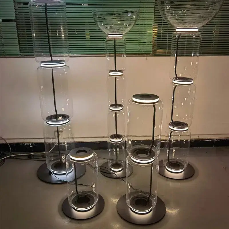 Modern stacked clear glass led floor lamp with illuminated circular bases and black cords for living room lighting