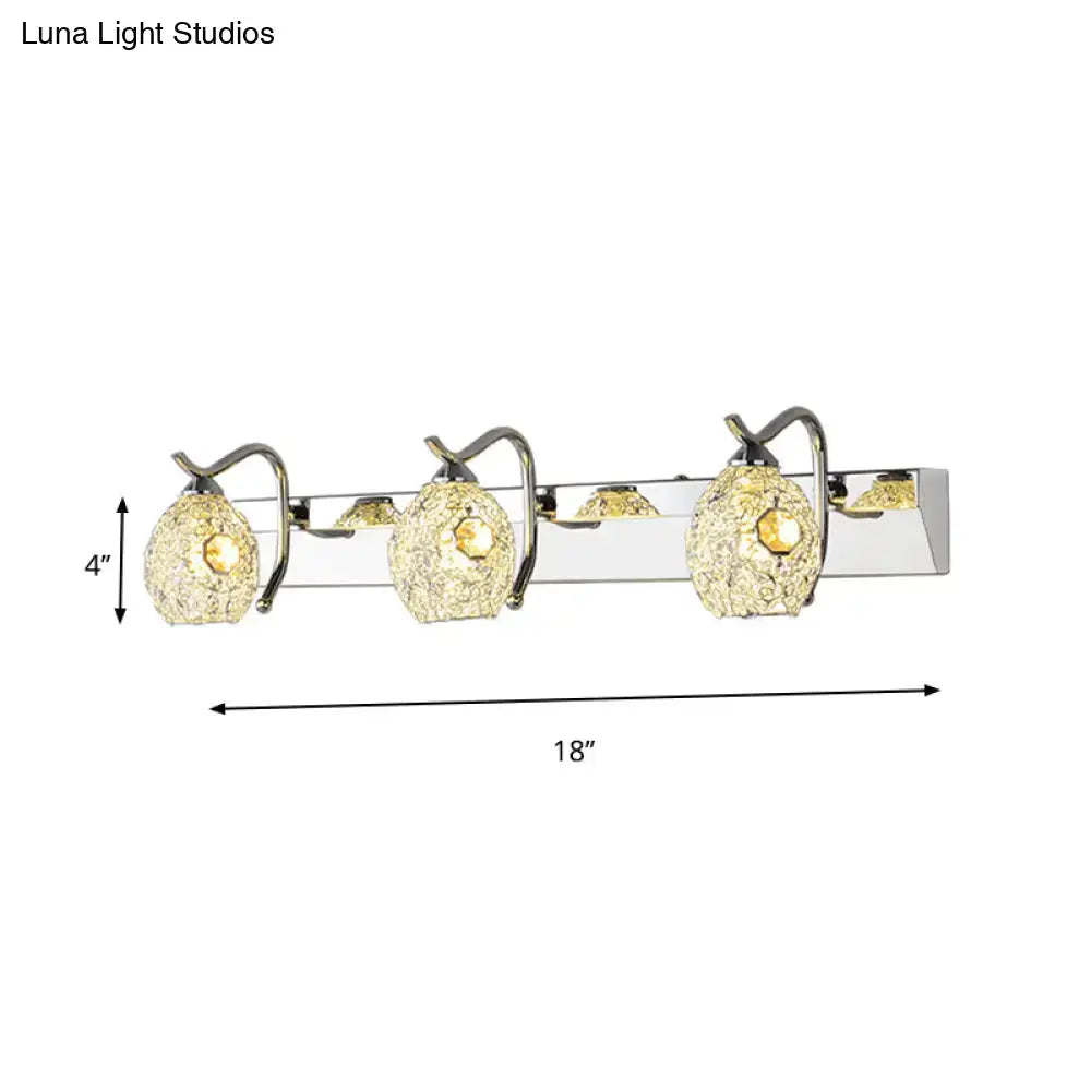 Modern stainless steel wall light with three pear-shaped textured glass shades emitting warm white light for bathroom