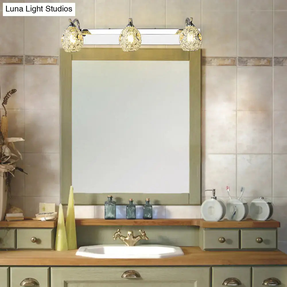 Modern stainless steel 3 head vanity wall light with warm white light and ornate golden frost glass globes above bathroom mirror