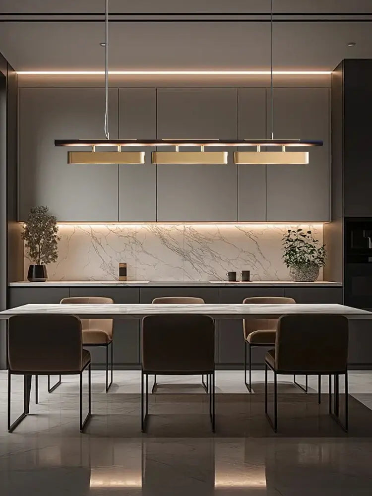 Modern stainless steel brushed gold pendant lamp above a minimalist dining table with white marble surface and dark metal legs