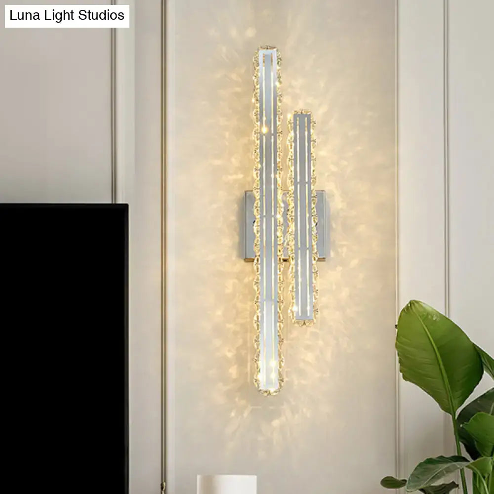 Modern stainless steel led wall mount light with two vertical k9 crystal rods emitting warm glow for living room
